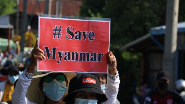 មនុស្សស្រីម្នាក់ក្នុងចំណោមក្រុមបាតុករលើកស្លាក Save Myanmar